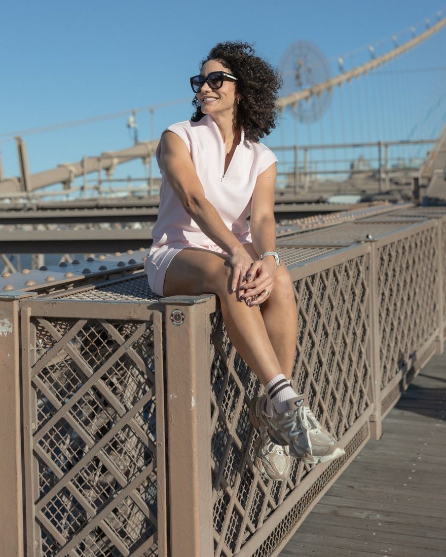 Kathy sorrindo sentada na Ponte do Brooklyn